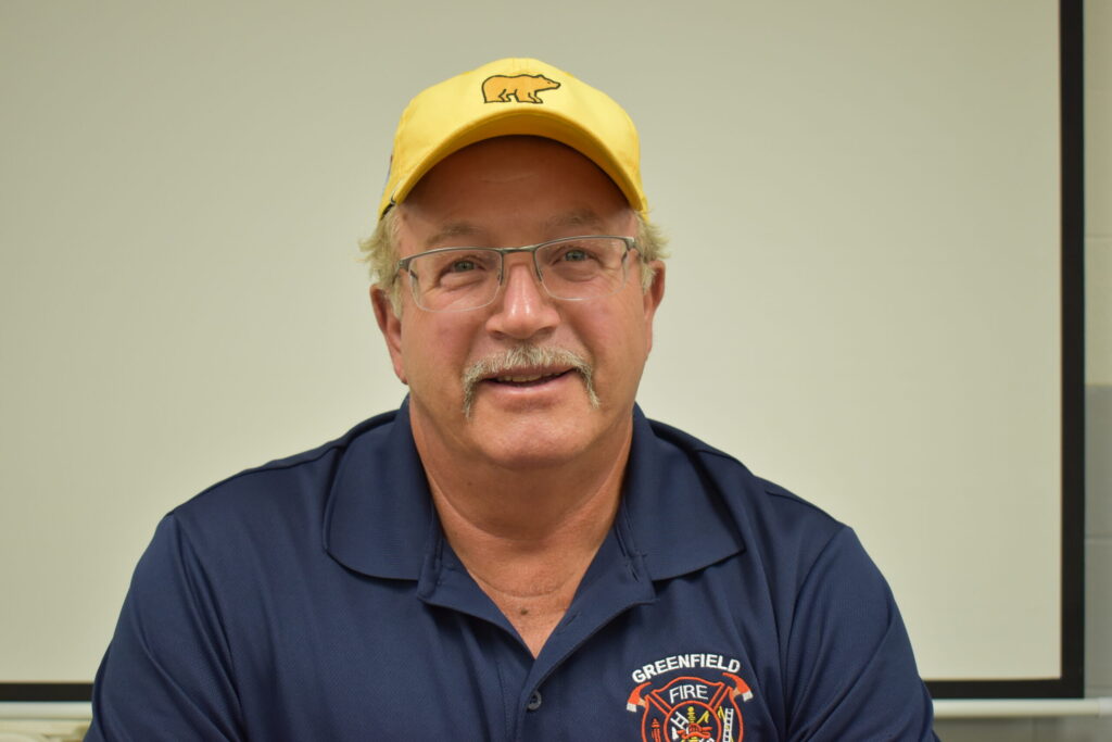 Man with a mustache, glasses and a baseball cap