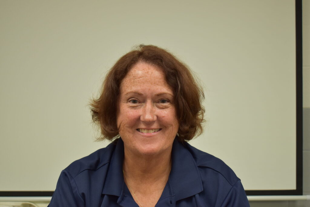 woman with blue shirt and shoulder length hair