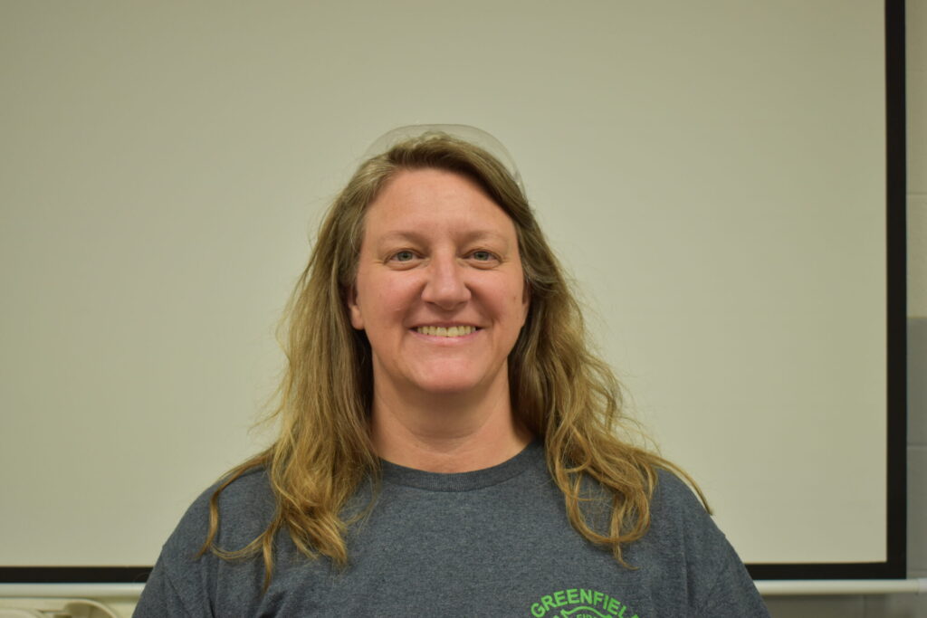 a woman with a grey shirt and longer than shoulder length hair