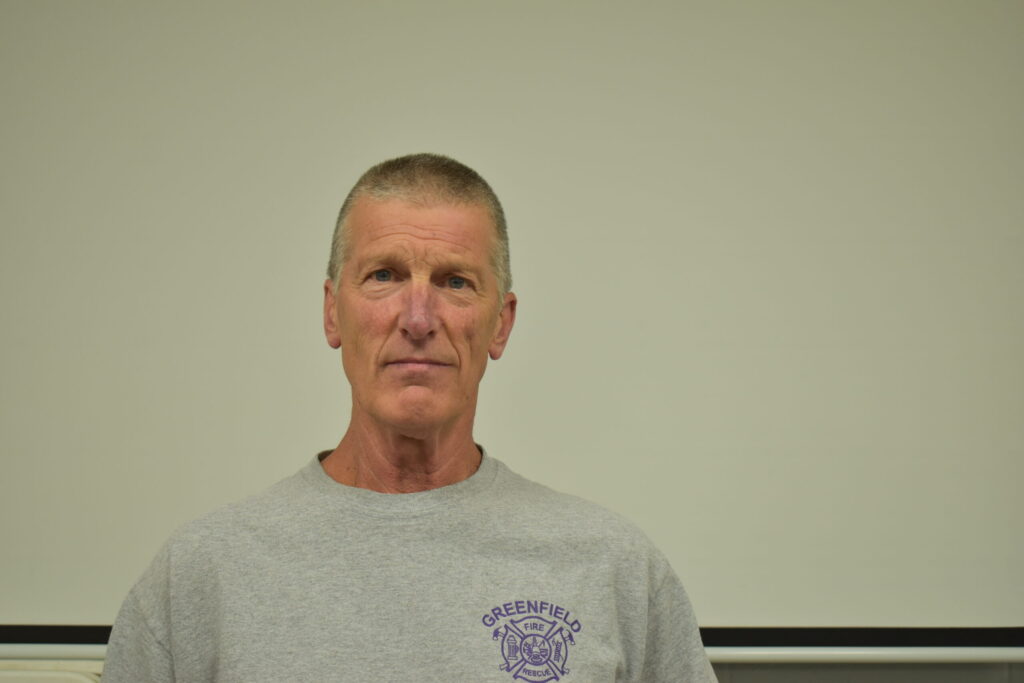 a man with a grey shirt and short hair