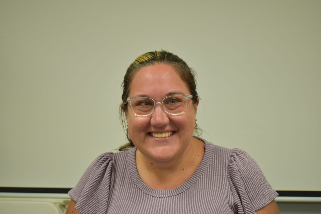 women in purple shirt with glasses and her hair pulled back